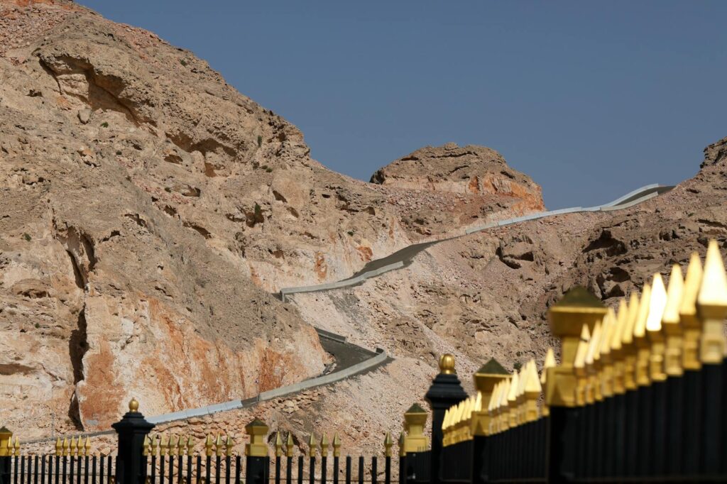 Road and Barren Mountains behind Golden Fence